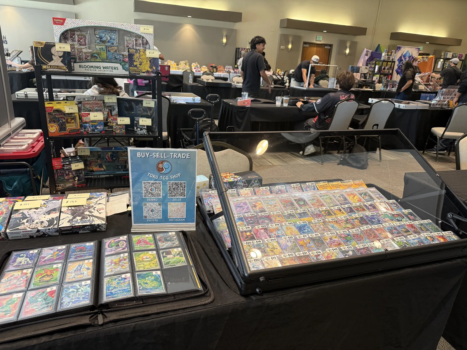 Toku TCG Shop's display case and booth at a card show